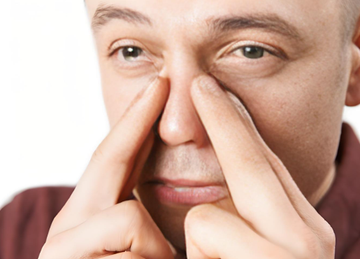 How should you breathe while rinsing your sinuses